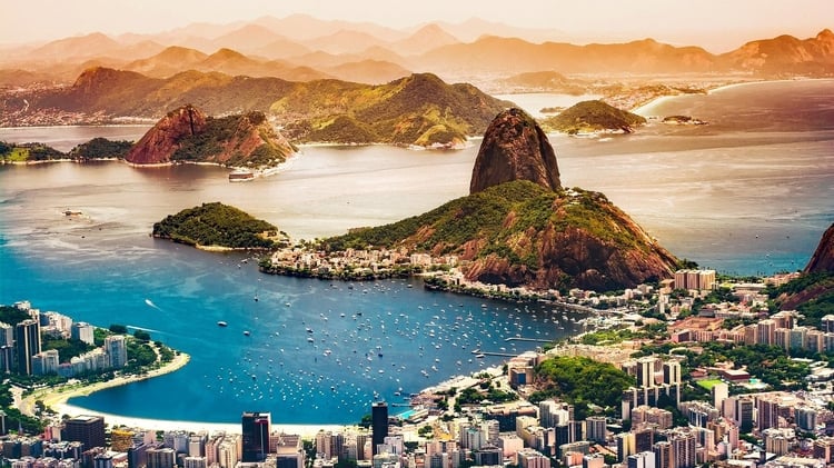 Rio de Janeiro from above with a view of the city, water, and mountains in the background