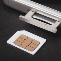 A prepaid SIM card about to be inserted into a phone by a traveler looking to save money on roaming fees while traveling