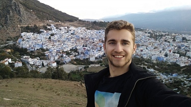 Sebastian from Travel Done Simple taking a selfie overlooking the city of Chefchaouen in Morocco