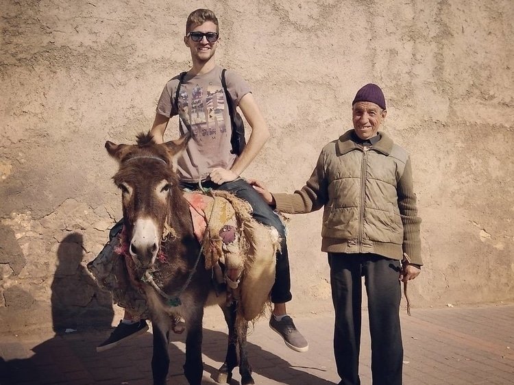 Sebastian from Travel Done Simple riding a donkey in Fez Morocco